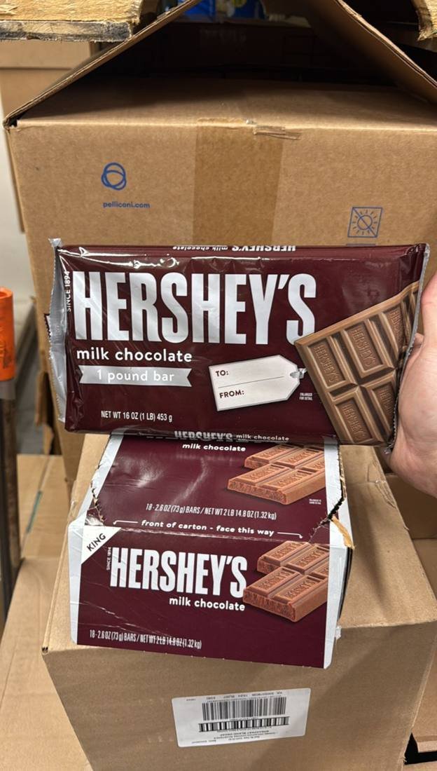 Cartons of Hershey's milk chocolate bars stacked in a warehouse for candy liquidation