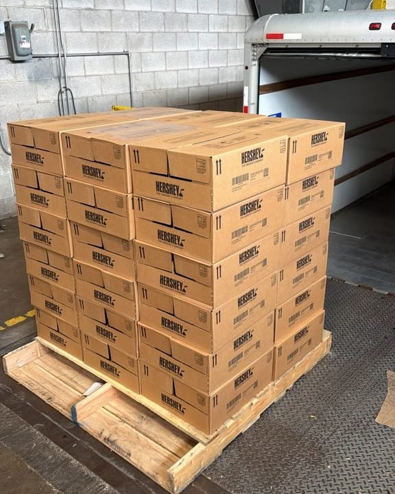 Pallet of Hershey’s cartons at a loading dock, ready to sell candy for cash